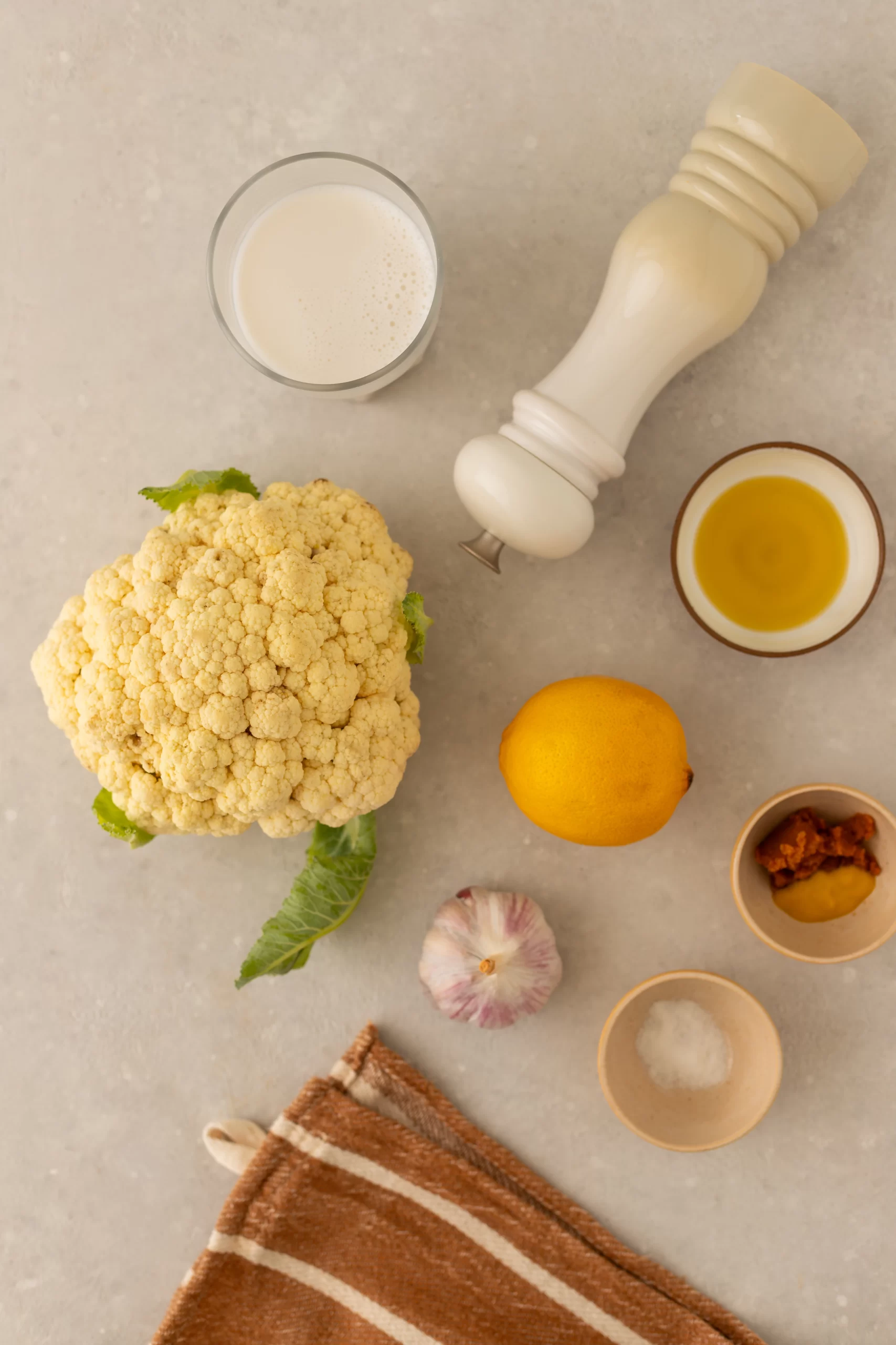 ingredientes do molho branco de couve-flor vegano e sem lactose: Para fazer essa receita, você só vai de: couve-flor, alho, azeite de oliva, suco de limão, leite vegetal, mostarda, missô, sal e pimenta do reino.